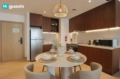 a kitchen and dining room with a table and chairs at HiGuest - Stylish 1BR Apartment in La Mer in Dubai
