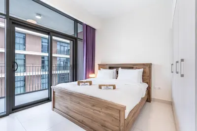 a bedroom with a bed and a large window at Premium Home in Park Point Near Dubai Hills Mall in Dubai