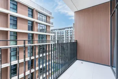 a balcony of a building with a red wall at Premium Home in Park Point Near Dubai Hills Mall in Dubai