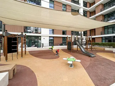 a playground in front of a building with a slide at Premium Home in Park Point Near Dubai Hills Mall in Dubai