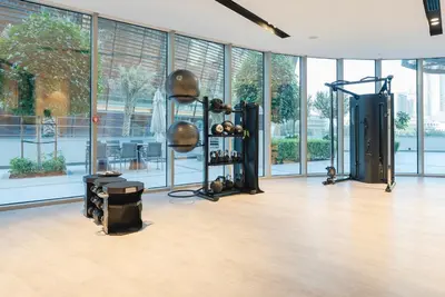 a room with a gym with a lot of windows at Downtown Luxury 2BR - Full Burj Khalifa & Fountain Views - 5 Minutes Walk to Dubai Mall in Dubai