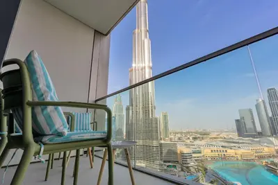 a balcony with two chairs and a view of a city at Downtown Luxury 2BR - Full Burj Khalifa & Fountain Views - 5 Minutes Walk to Dubai Mall in Dubai
