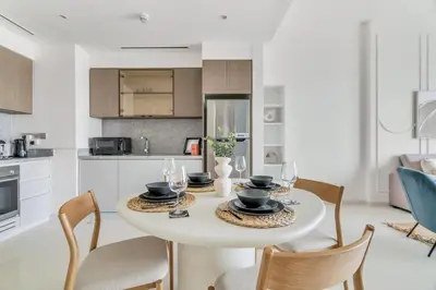 a kitchen and dining room with a white table and chairs at GuestReady - Amazing home with a Great sea view in Dubai