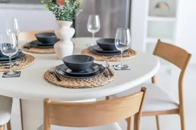 a white dining room table with black dishes and wine glasses at GuestReady - Amazing home with a Great sea view in Dubai