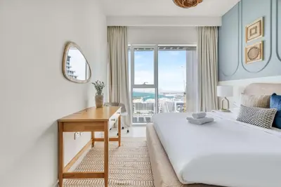 a bedroom with a bed and a desk with a window at GuestReady - Amazing home with a Great sea view in Dubai