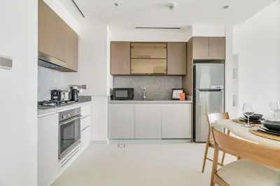 a kitchen with white appliances and a table with chairs at GuestReady - Amazing home with a Great sea view in Dubai