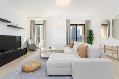 a living room with a white couch and a tv at Spacious 1-Bedroom at the Heart of JBR in Dubai
