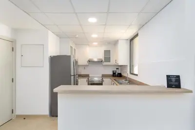 an empty kitchen with white walls and white counters at Spacious 1-Bedroom at the Heart of JBR in Dubai