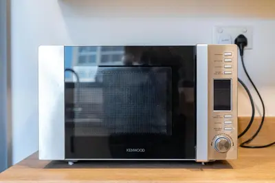 a microwave oven sitting on top of a table at Spacious 1-Bedroom at the Heart of JBR in Dubai