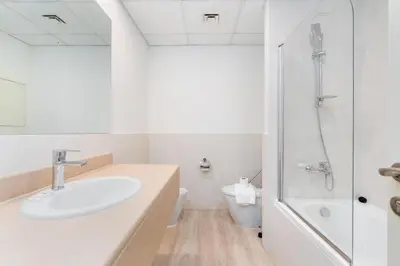 a white bathroom with a sink and a toilet at Spacious 1-Bedroom at the Heart of JBR in Dubai