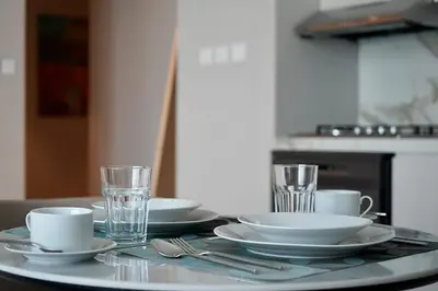 a table with plates and cups and glasses on it at Condor Marina Star Seaview Studio, Dubai Marina in Dubai