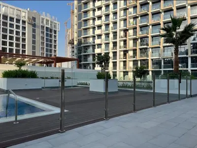 a boardwalk in front of a building with palm trees at AMLY holiday home DUBAI in Dubai