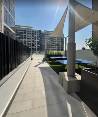 a patio with tables and benches in a building at AMLY holiday home DUBAI in Dubai