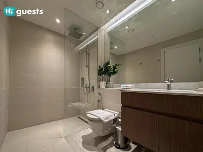 a bathroom with a toilet and a sink and a mirror at HiGuest - Elegant 1BR Oasis in La Mer in Dubai