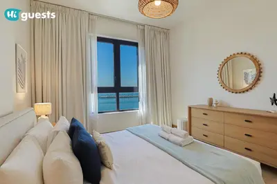 a bedroom with a large bed with a large window at HiGuest - Elegant 1BR Oasis in La Mer in Dubai