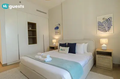 a bedroom with a large bed with towels on it at HiGuest - Elegant 1BR Oasis in La Mer in Dubai