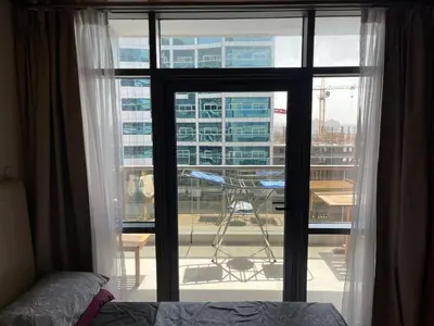a bedroom with a window with a view of a building at Cozy Studio in Dubai