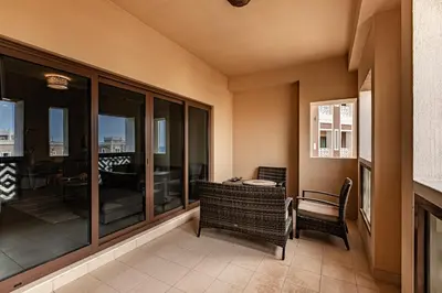 a room with a balcony with a table and chairs at Balqis I Renovated 3BDR with 1 maid room I Palm Jumeirah in Dubai