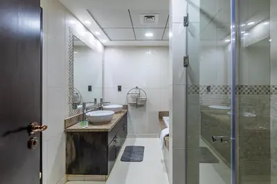 a bathroom with two sinks and a shower at Balqis I Renovated 3BDR with 1 maid room I Palm Jumeirah in Dubai