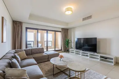 a living room with a couch and a tv at Balqis I Renovated 3BDR with 1 maid room I Palm Jumeirah in Dubai