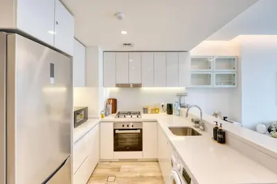 a white kitchen with white cabinets and a sink at Classic BNB - Ahad Large 1BR for 4 in Dubai