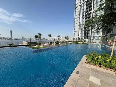 a large swimming pool in front of a tall building at Creek edge,1 bedroom apartment, creek Harbour, high Floor in Dubai