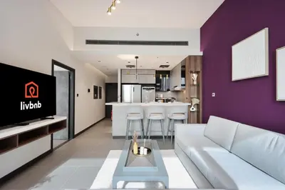 a living room with a white couch and a purple wall at Livbnb-Embrace Luxury and Comfort in Prime 1BR,JLT in Dubai