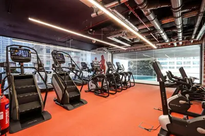 a gym with several treadmills and elliptical machines at Livbnb-Embrace Luxury and Comfort in Prime 1BR,JLT in Dubai