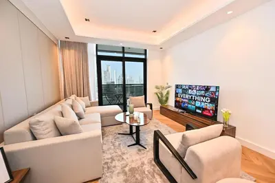 a living room with white furniture and a tv at Stunning 1Bdr Luxury with Burj Khalifa View in Dubai