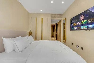 a bedroom with a large white bed and a tv at luxury penthouses see view at five in Dubai