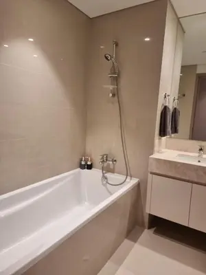 a white bath tub in a bathroom with a sink at Luxury 2 Bedroom Act 1 Apartment in Dubai
