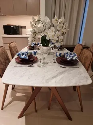 a white table with a vase of flowers on it at Luxury 2 Bedroom Act 1 Apartment in Dubai