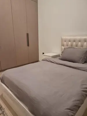 a bedroom with a large bed and a cabinet at Luxury 2 Bedroom Act 1 Apartment in Dubai