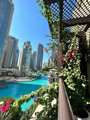 a view of a river in a city with pink flowers at Dubai mall Aparment in Dubai