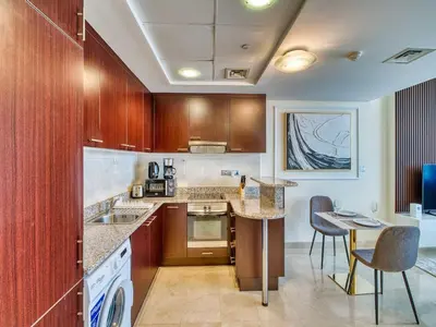 a kitchen with wooden cabinets and a table and chairs at Classic Sky Studio Bright in Dubai
