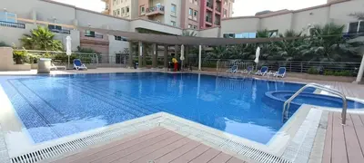 a large swimming pool in a hotel with chairs at Cozy Family-Friendly 2BR in JVT in Dubai