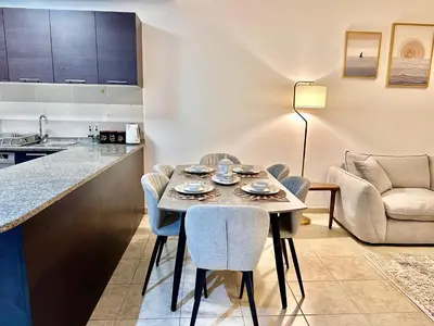 a kitchen and dining room with a table and chairs at Cozy Family-Friendly 2BR in JVT in Dubai