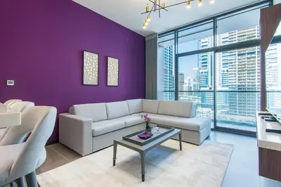 a living room with purple walls and a couch and a table at MBL Royal, JLT -One Bedroom with Lake View in Dubai