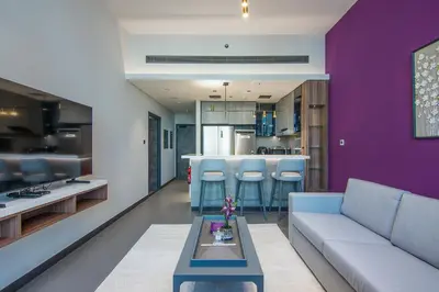 a living room with a couch and a kitchen at MBL Royal, JLT -One Bedroom with Lake View in Dubai