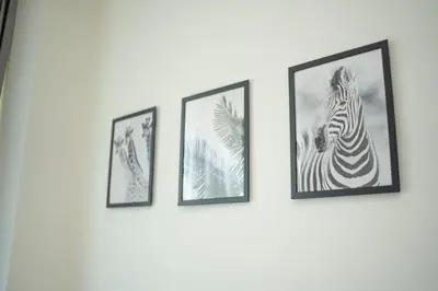 four framed pictures of a zebra on a wall at AWS Holiday Homes - Perfect Dubai Stay! in Dubai