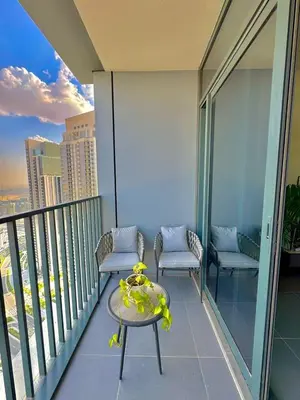 a balcony with two chairs and a table on a building at Creek edge,1 bedroom apartment, creek Harbour, high Floor in Dubai