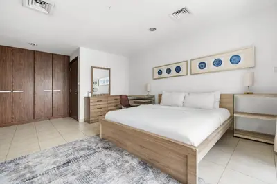 a bedroom with a large bed and a desk at 3BR plus Maid Executive Tower L, City View in Dubai