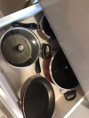 a bunch of pots and pans hanging from a kitchen counter at Pet Free Studio Apartment Close Downtown Fast Wi-fi in Dubai