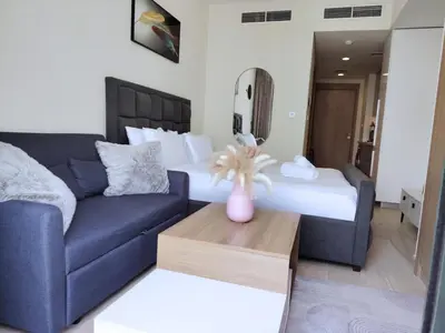 a living room with a blue couch and a bed at Pet Free Studio Apartment Close Downtown Fast Wi-fi in Dubai