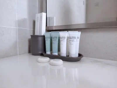 a bathroom counter with a shelf with threeials of moisturizers at Pet Free Studio Apartment Close Downtown Fast Wi-fi in Dubai