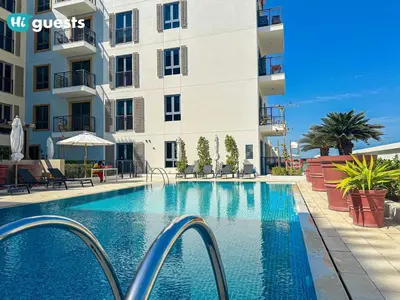 a swimming pool in front of a building at HiGuest - Coastal Luxury 2BR in La Mer Beachside Bliss in Dubai