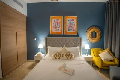 a bedroom with a bed and a yellow chair at Bnbeyond's Sheek Studio at Studio One tower in Dubai