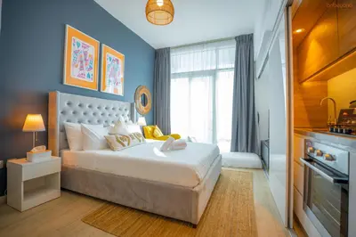 a bedroom with a large bed with blue walls at Bnbeyond's Sheek Studio at Studio One tower in Dubai