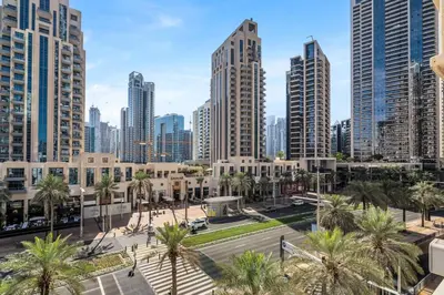 a city skyline with tall buildings and palm trees at GuestReady - Luxe 1BD Near Dubai Mall | 29 Blvd in Dubai