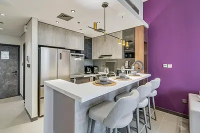 a kitchen with purple walls and a counter with stools at GuestReady - Stylish haven with lake views in Dubai